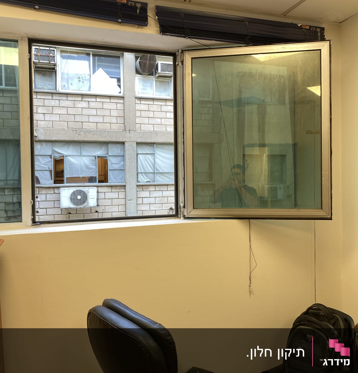 תריסים פתוחים מעל חלון זכוכית במשרד